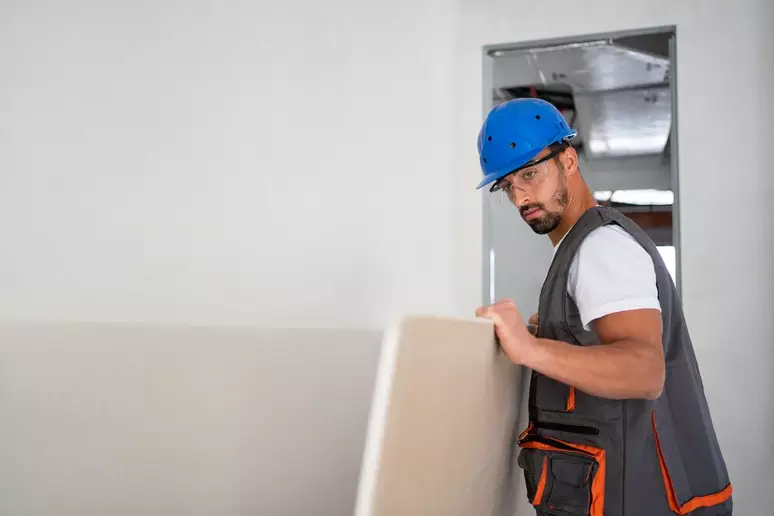 Profissional instalando drywall em uma obra seguindo a nova norma ABNT NBR 15217-2025.